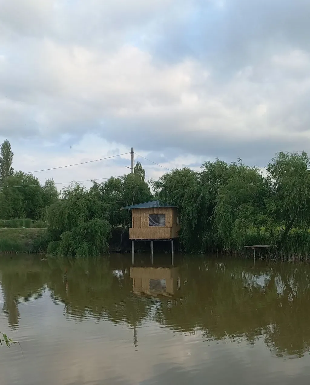 Hovuz suvi ustida ustunlarga qurilgan baliqchi uychasi